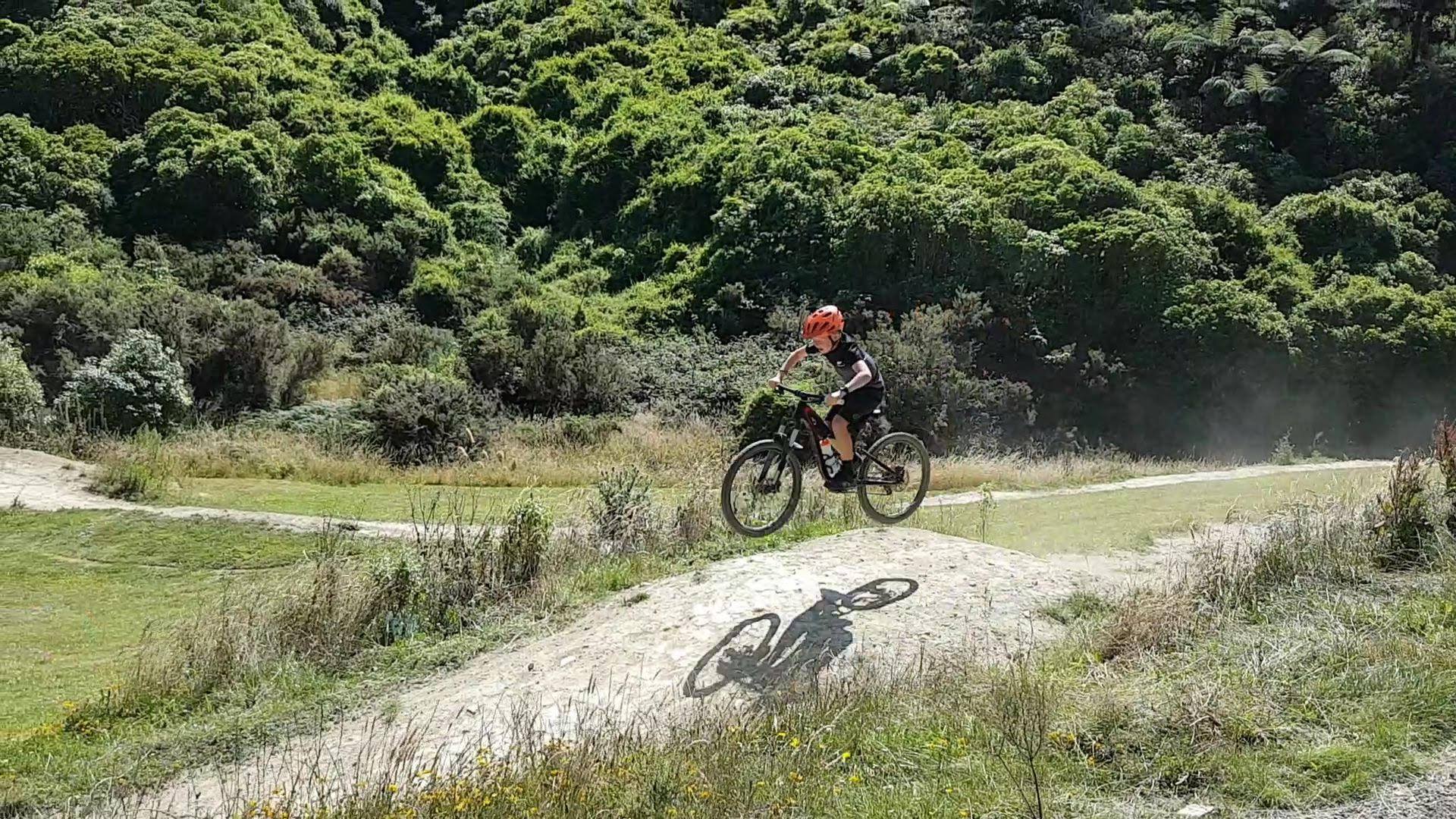 A child mountain biking along a track at Belmont Park