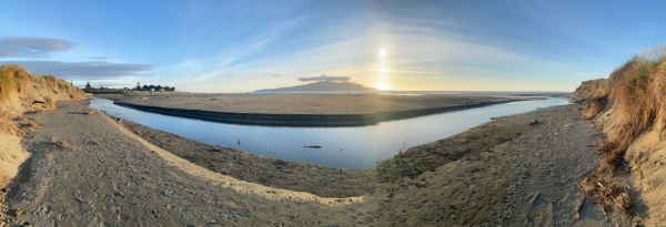 View of Waimeha Stream’s position on Waikanae Beach, seen from the dune near Field Way and facing west toward the sea, with Kāpiti Island visible on the horizon.