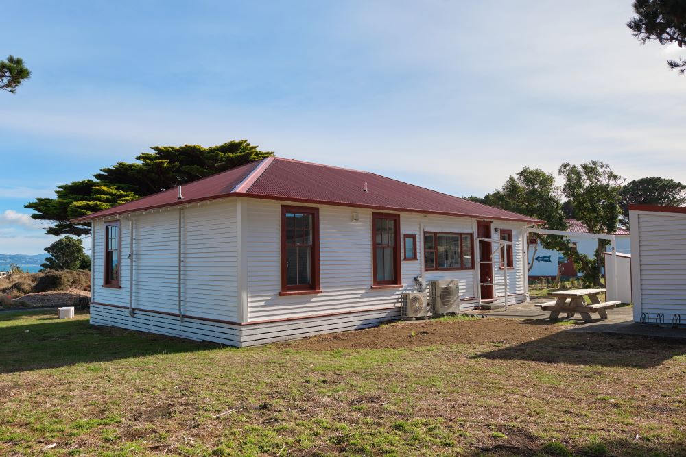 View of the outside of the cottage, showing a picnic table, washing line, and bike rack