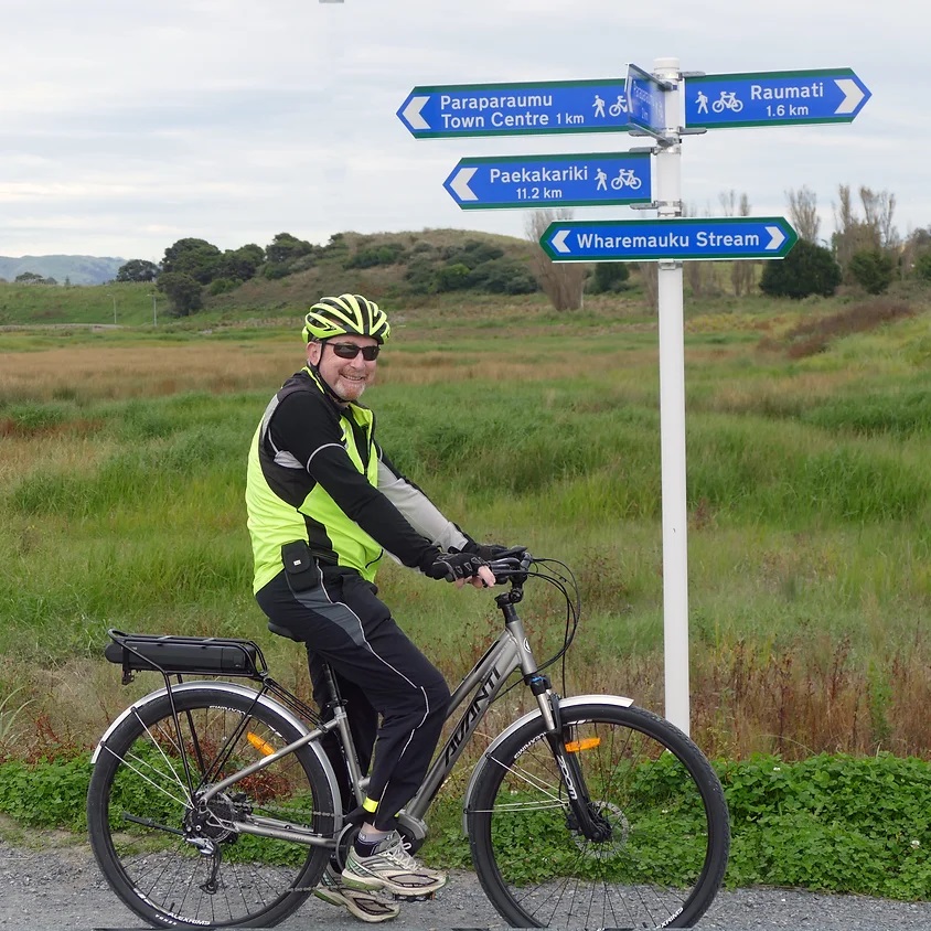 A man on a bike smiles at the camera