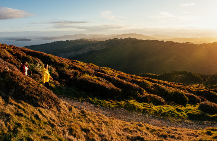 A couple walking along Belmont Trig track at sunset