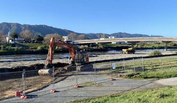 A digger working on a temporary rockline on the bank of Te Awa Kairangi/Hutt River for flood protection