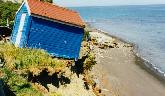 A shed on the edge of a cliff, close to falling after the cliff has eroded