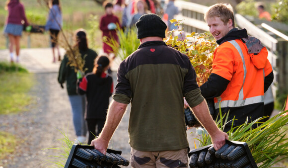 Rangers and community members carrying plants at a Planting Day